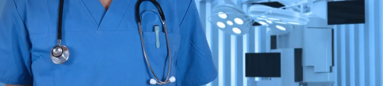 Medical professional in scrubs with a stethoscope standing in an operating room.